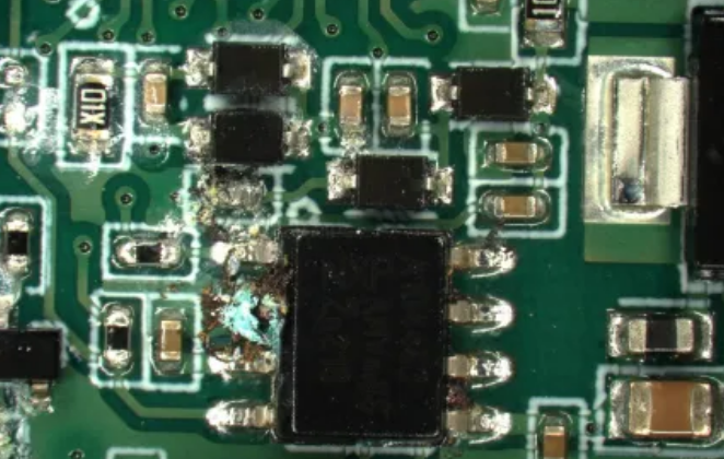 烧毁PCBA外观特写：展示电路板局部碳化、发黑及元件损坏的故障现象
